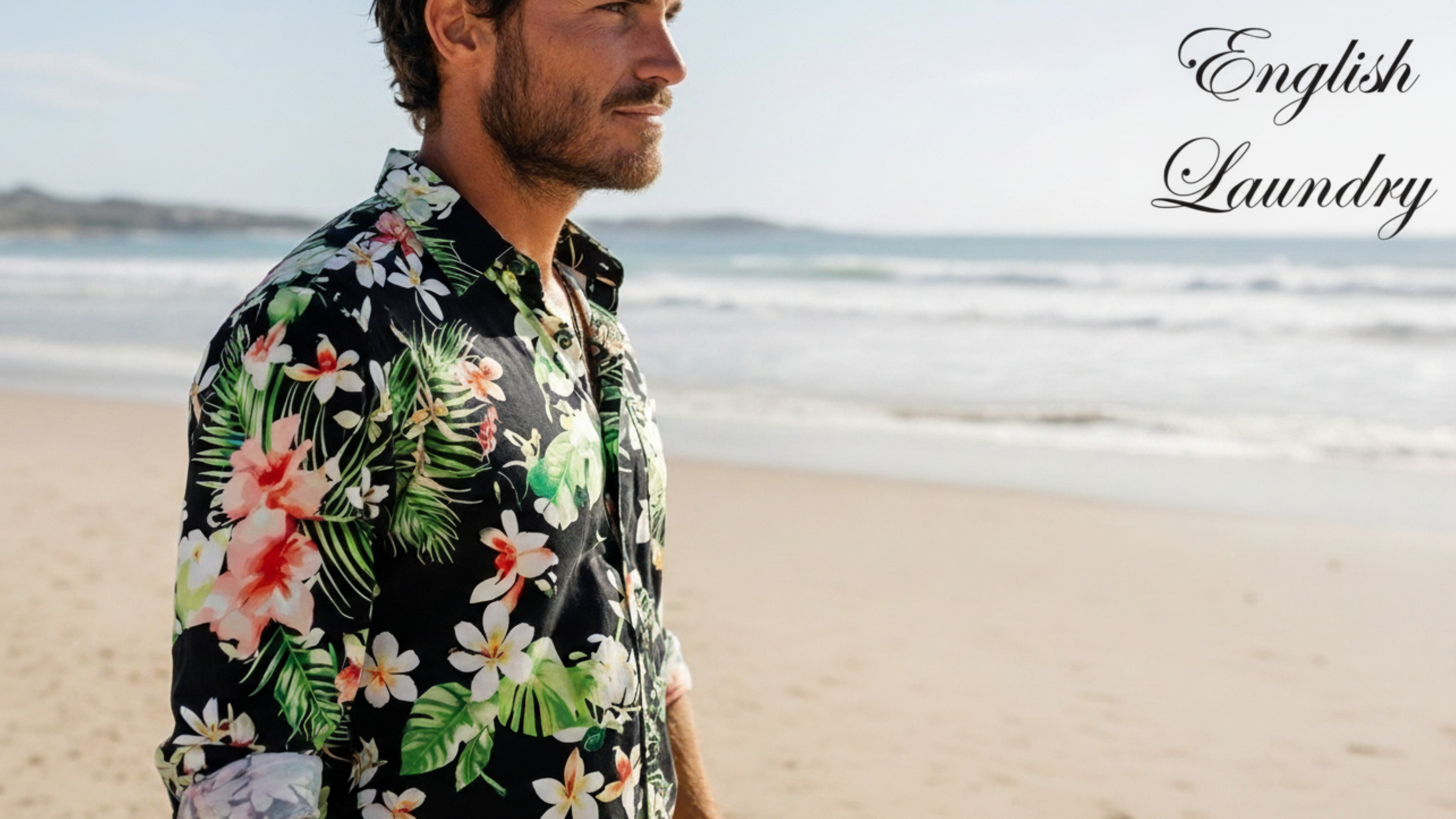 Man wearing a floral shirt on a beach with 'English Laundry' branding.